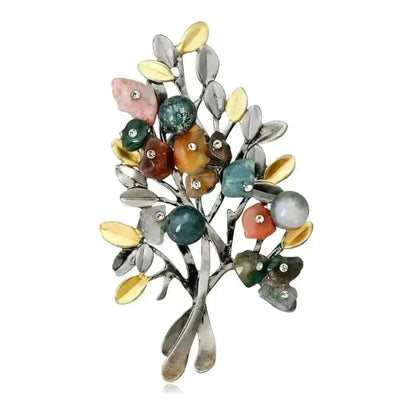 colored stone christmas tree brooch on a white background
