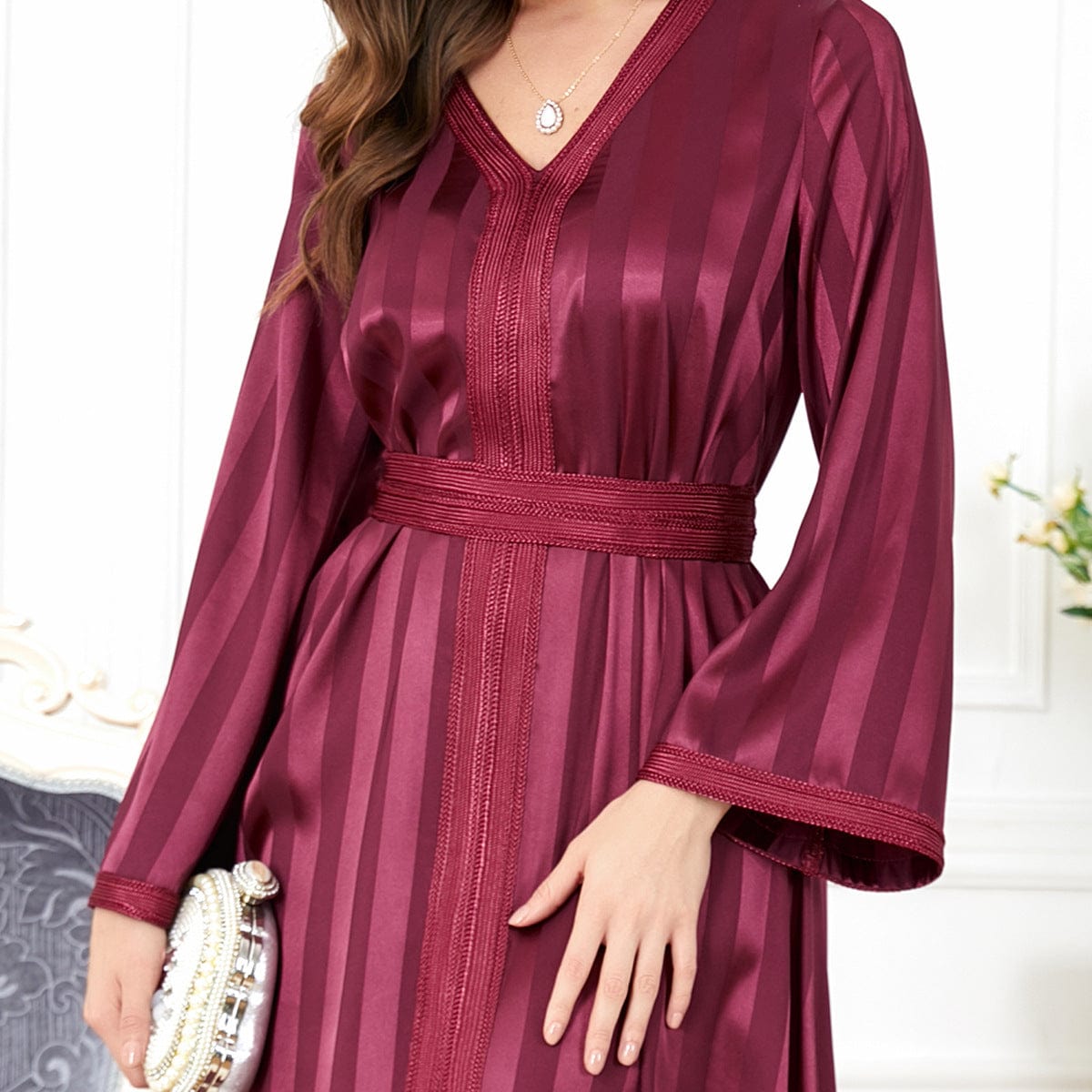 a woman wearing a wine red long sleeved european american dress close up