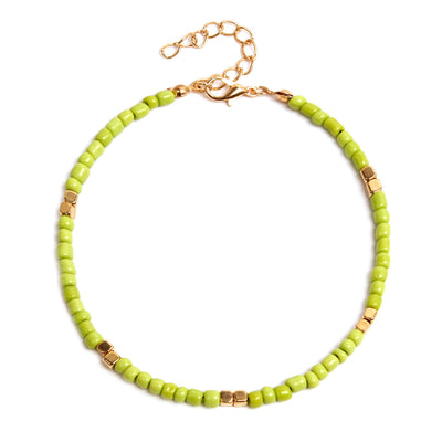 anklet  with green beads and gold accents on a white background