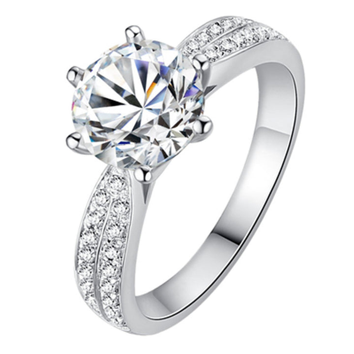 Silver ring with a large central gemstone and smaller stones on the band against a white background