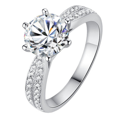 Silver ring with a large central gemstone and smaller stones on the band against a white background