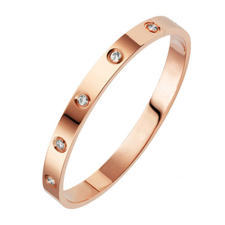 Rose gold ring with embedded diamonds on a white background