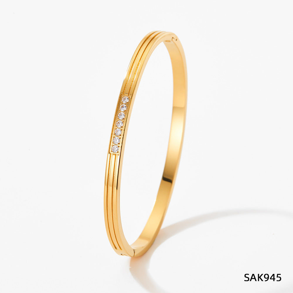 Gold bracelet with small diamonds on a white background