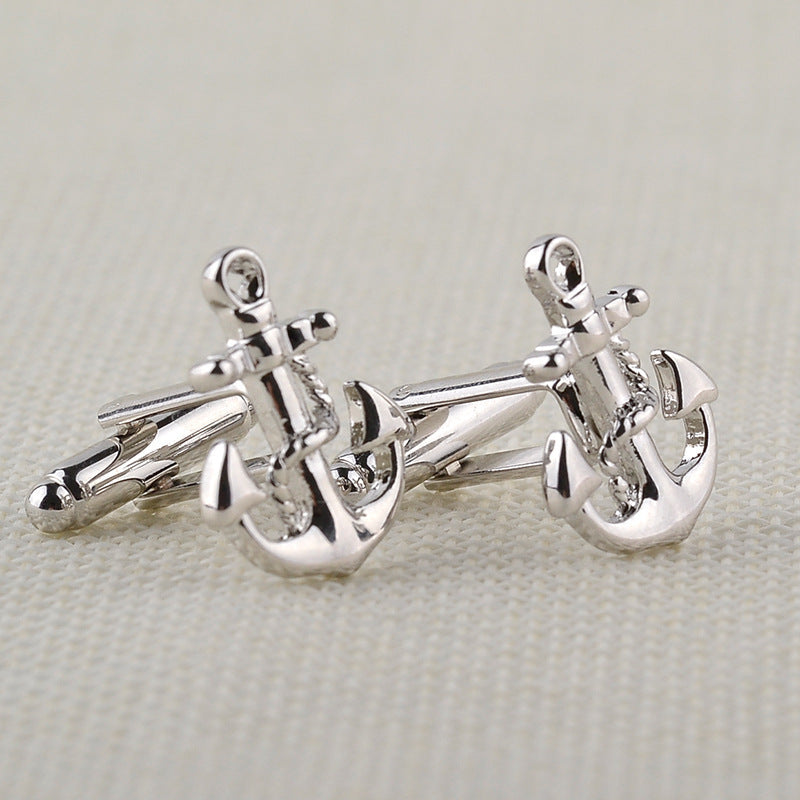 Silver anchor cufflinks on a light gray background