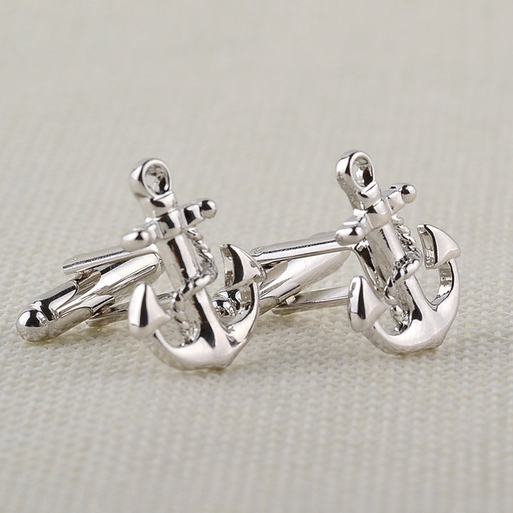 Silver anchor cufflinks on a light gray background