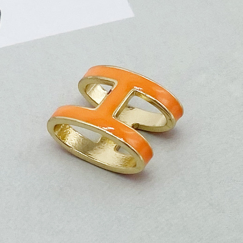 Pair of orange and gold earrings on a light gray background
