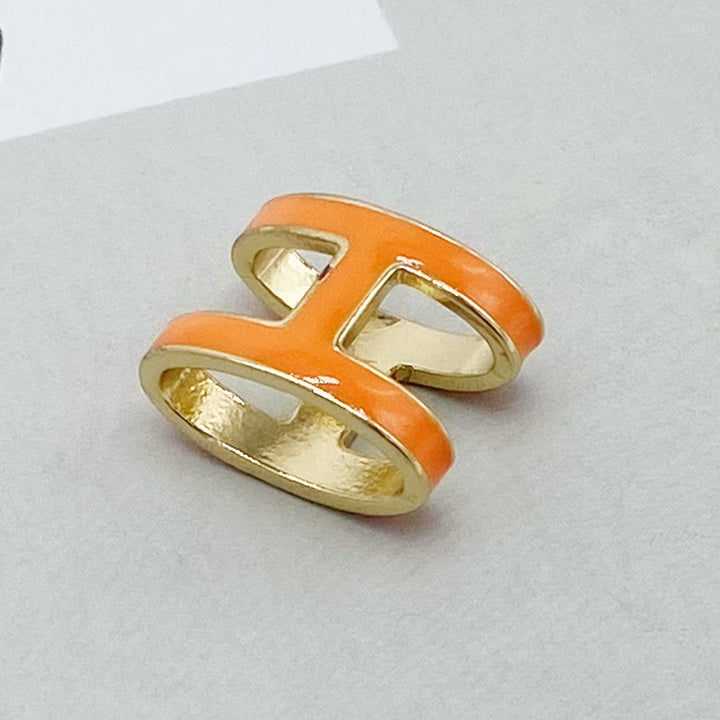 Pair of orange and gold earrings on a light gray background