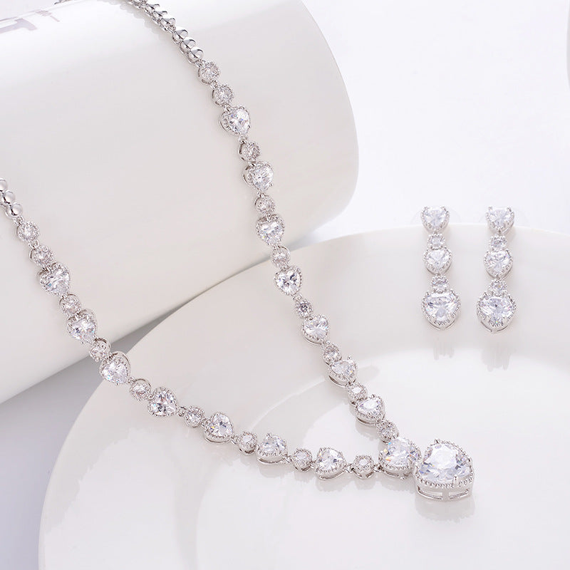 Silver necklace and earrings set on a white background
