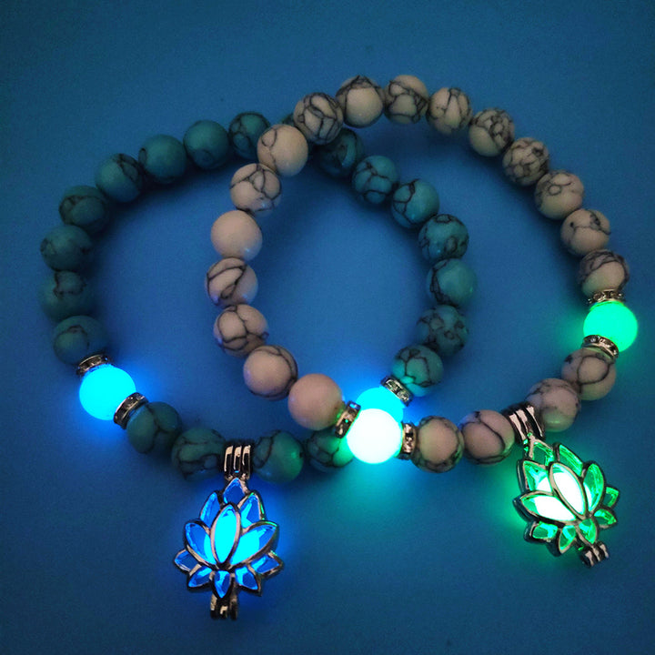 Glowing beaded bracelets with lotus flower charms on a blue background