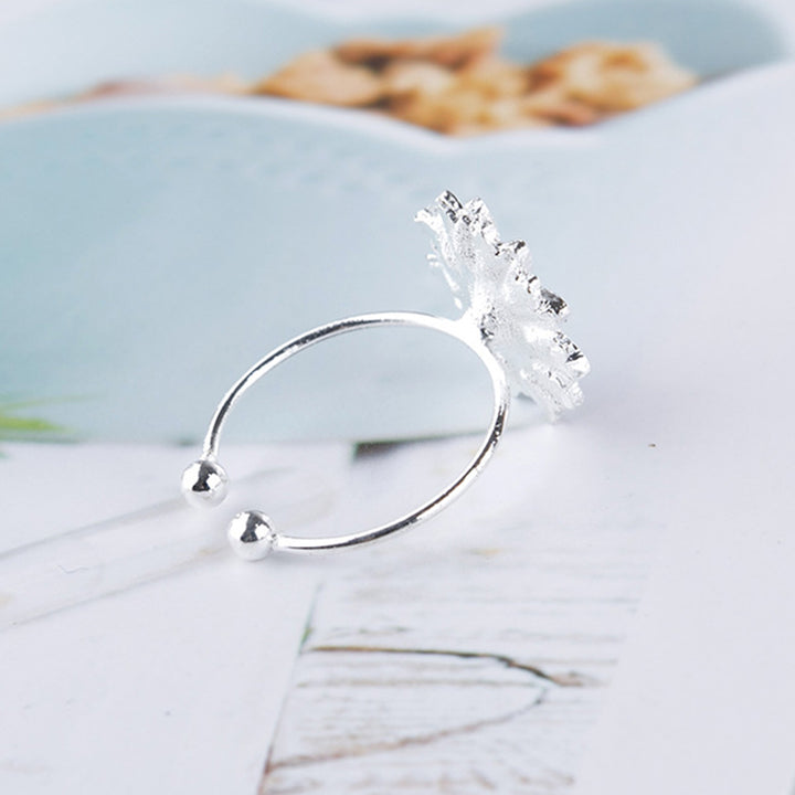 Back view of a Silver ring with a decorative element on a light background