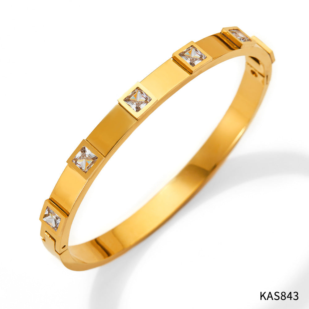 Gold bracelet with embedded diamonds on a white background