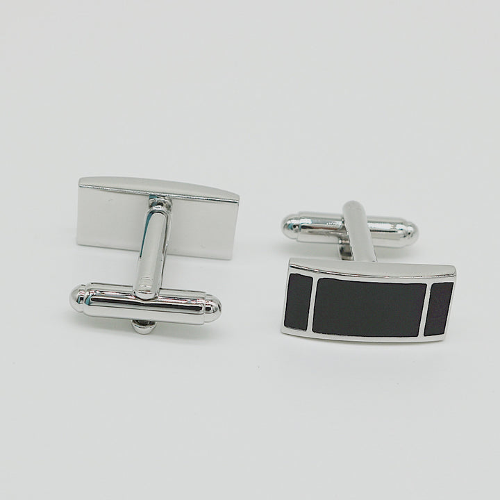 Silver cufflinks with a black rectangular accent on a light gray background