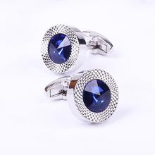 Pair of cufflinks with blue gemstones on a white background