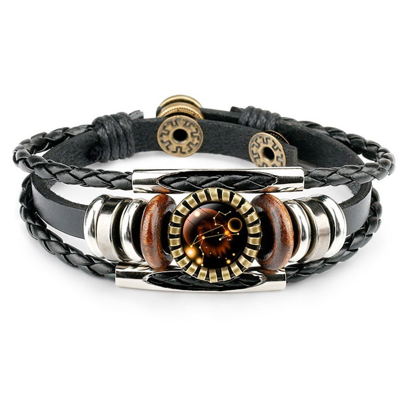 Black braided leather bracelet with a central round pendant featuring a galaxy design, accented by wood and metal beads, conveying a stylish, cosmic vibe.
