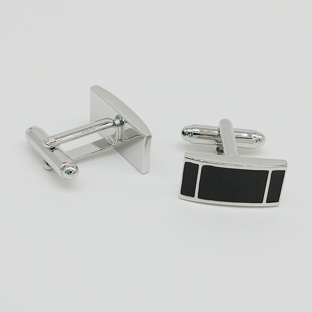 Silver cufflinks with a black rectangular design on a white background