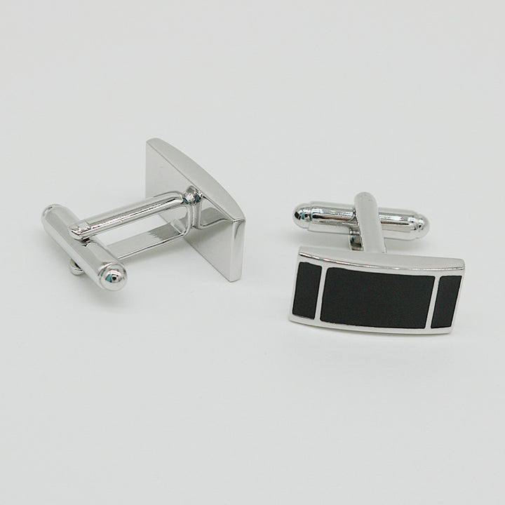 Silver cufflinks with a black rectangular design on a white background