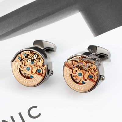 Mechanical cufflinks with intricate design on a white background