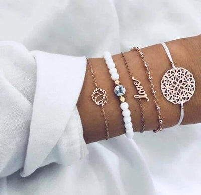 Close-up of a wrist wearing multiple bracelets with various designs on a white background
