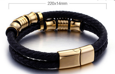 Black braided leather bracelet with gold metal clasps on a reflective surface.