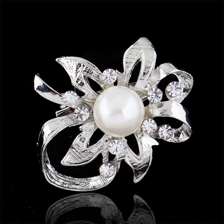 Silver brooch with a pearl and crystals on a black background