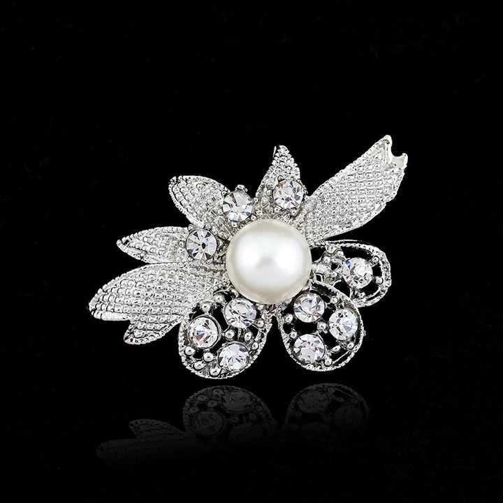 Decorative brooch with pearl and crystals on a black background