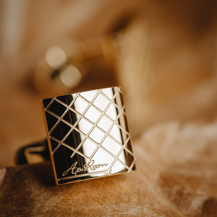 golden cufflinlink with brand name on a blurred background