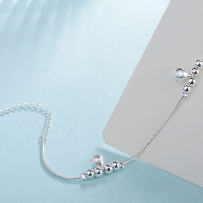 Silver beaded bracelet on a light blue background