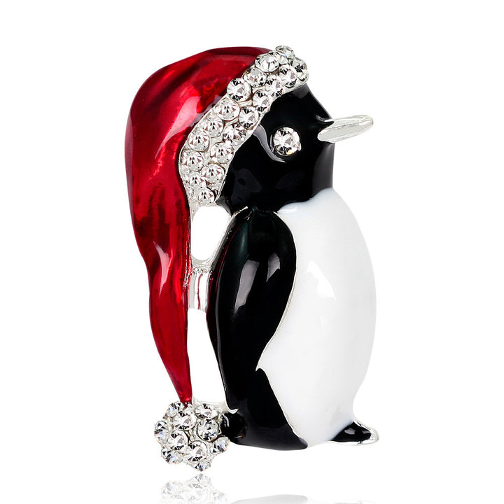 Penguin figurine wearing a red hat with rhinestones on a white background