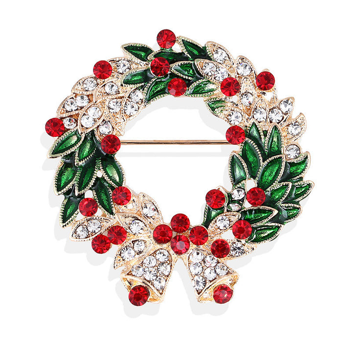 Christmas wreath brooch with red berries and green leaves on a white background