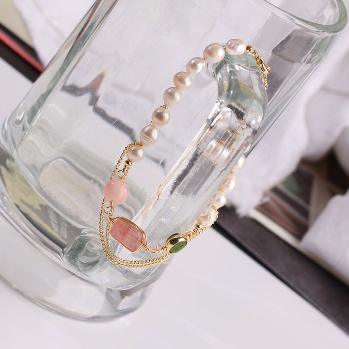Pearl and gemstone bracelet on a glass stand with a blurred background
