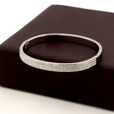Silver bracelet on a dark brown surface