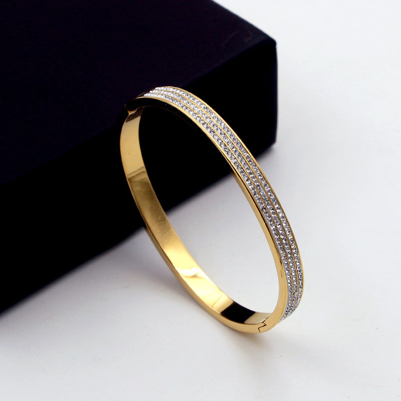 Gold bracelet with diamond accents on a white background