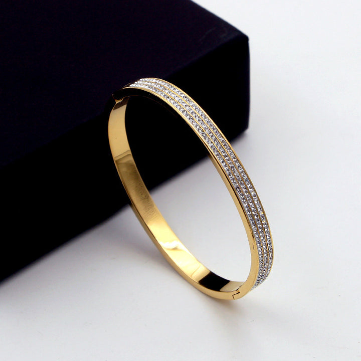 Gold bracelet with diamond accents on a white background