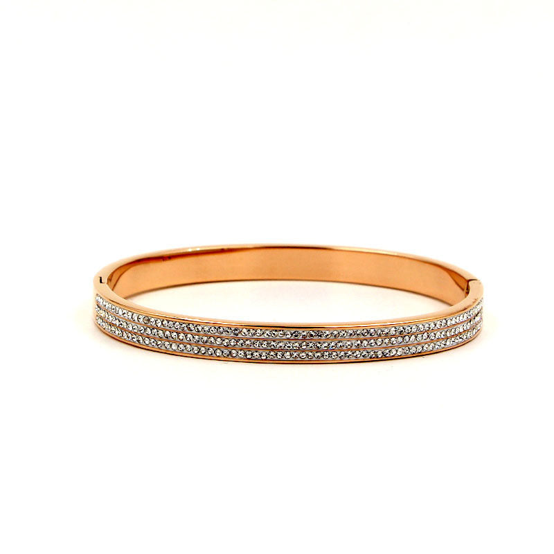 Rose gold bracelet with clear gemstones on a white background