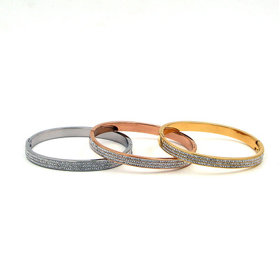 Three metallic bracelets in silver, rose gold, and gold on a white background