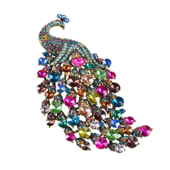 Multicolored jeweled peacock brooch on a white background