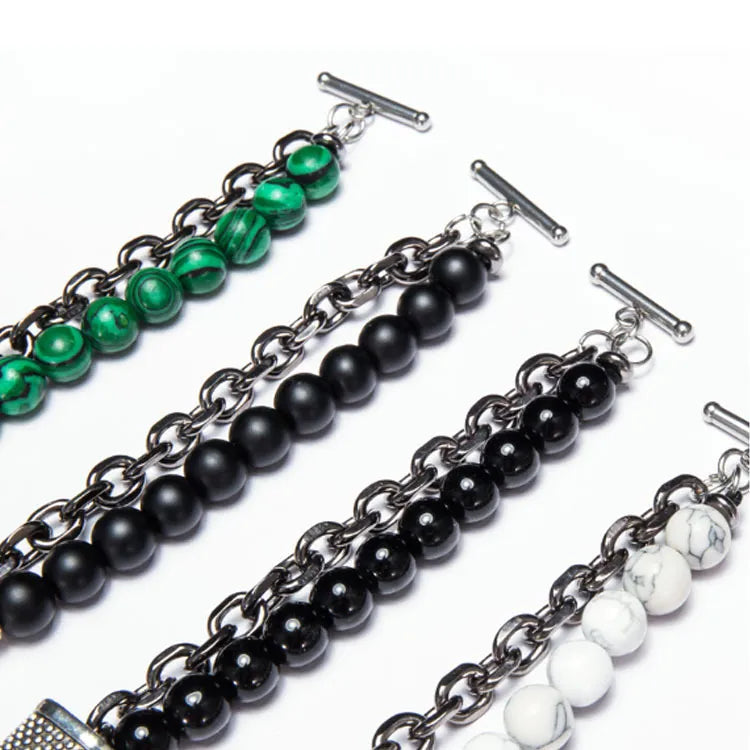 Set of four beaded bracelets with chain links on a white background