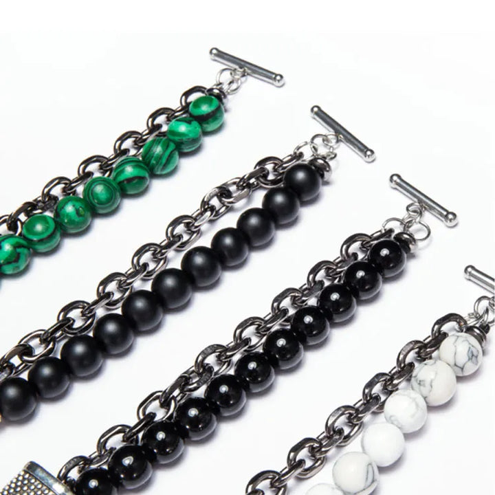 Set of four beaded bracelets with chain links on a white background