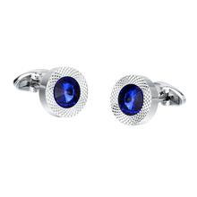 Pair of silver cufflinks with blue gemstones on a white background