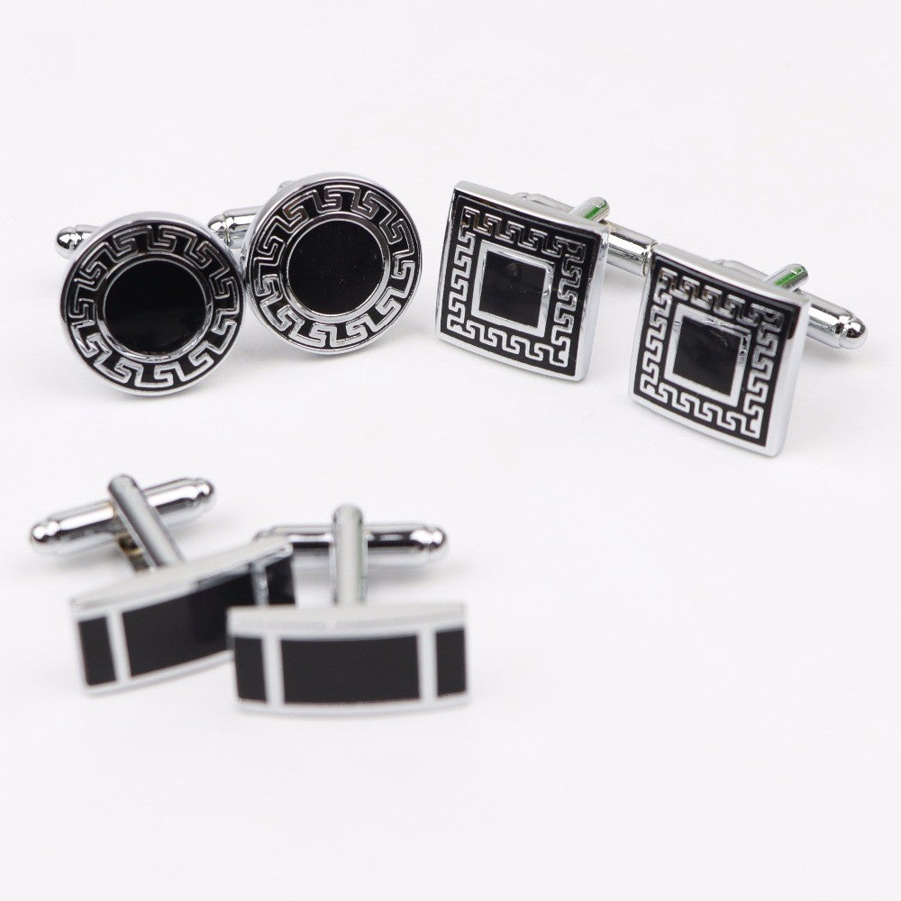 Set of black and silver cufflinks on a white background
