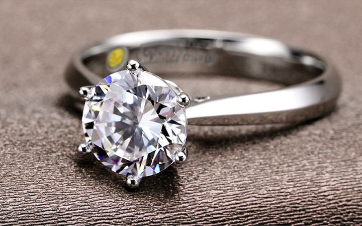 Silver ring with a large zircon  on a textured brown surface