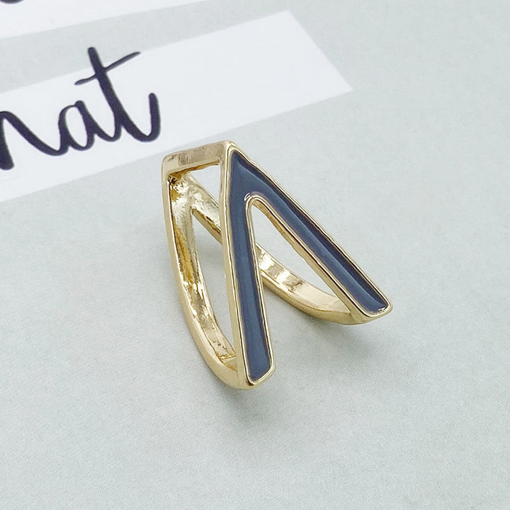 Gold ring with blue inlay on a light gray background