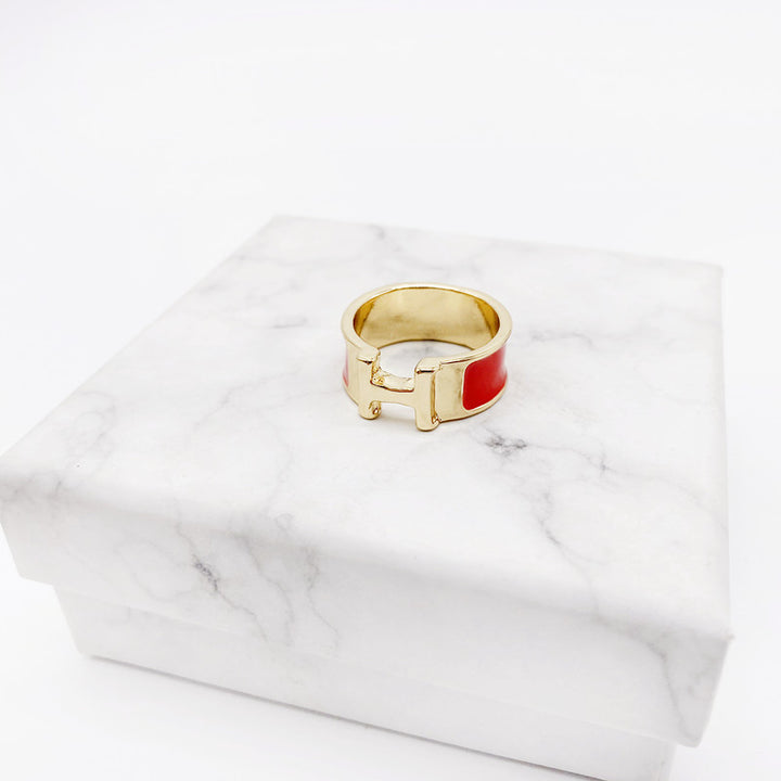 Gold ring with a red center on a marble surface