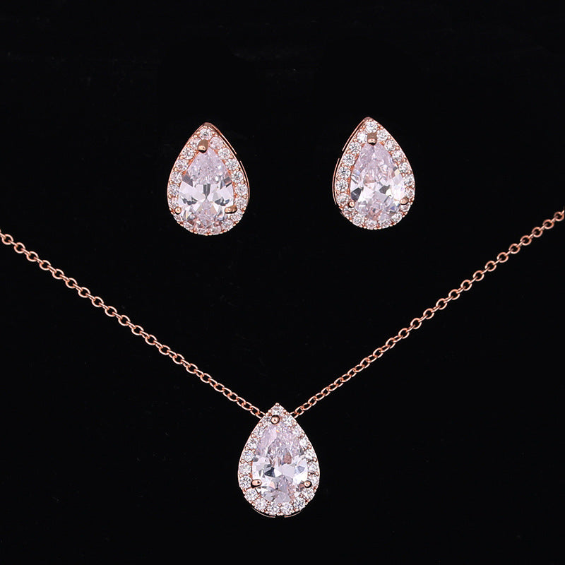 Jewelry set with teardrop-shaped earrings and necklace on a black background