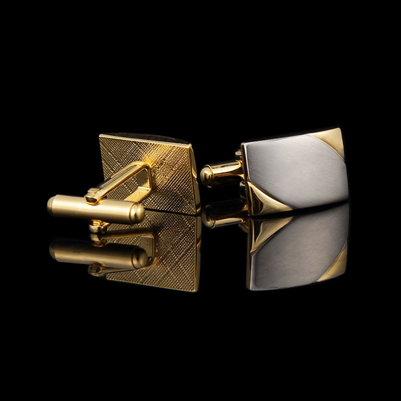 Gold and silver cufflinks on a black background