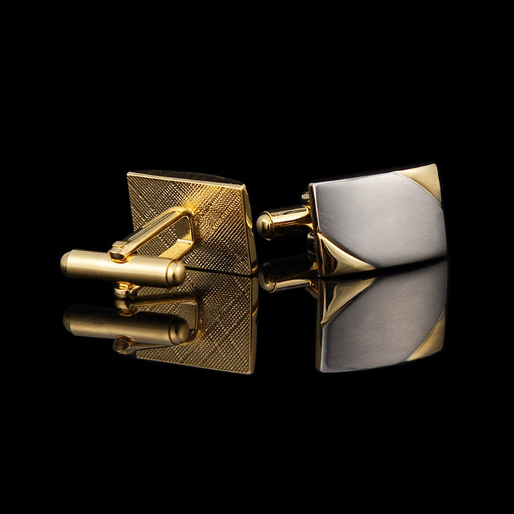 Gold and silver cufflinks on a black background
