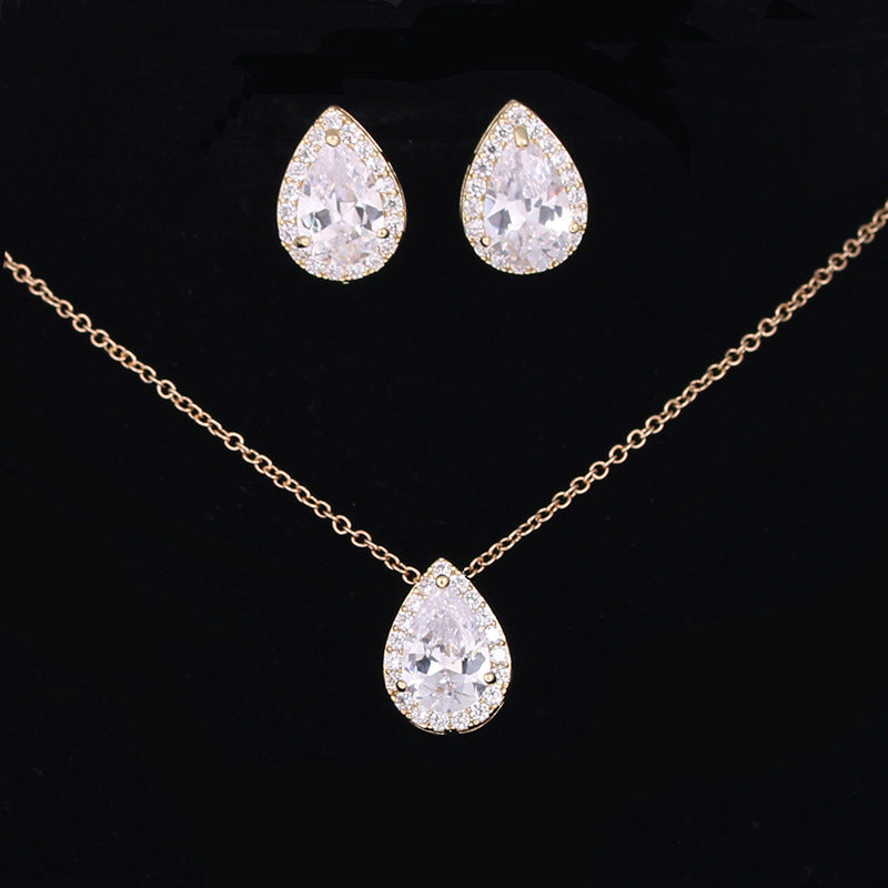 Jewelry set with teardrop-shaped crystal necklace and earrings on a black background