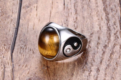 lateral view of a Silver ring with a tiger's eye stone on a wooden surface