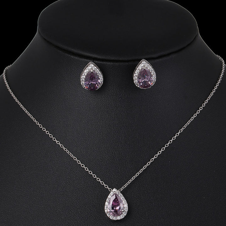Jewelry set with necklace and earrings featuring purple teardrop stones on a black mannequin.
