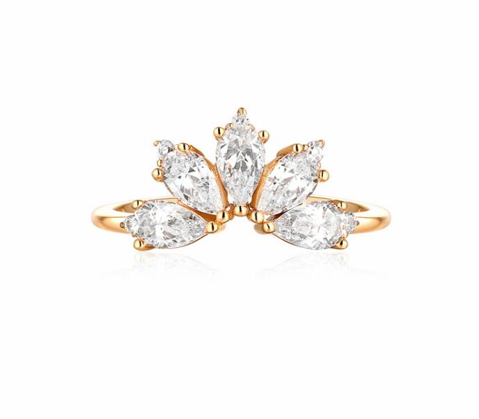 Gold ring with clear gemstones on a white background